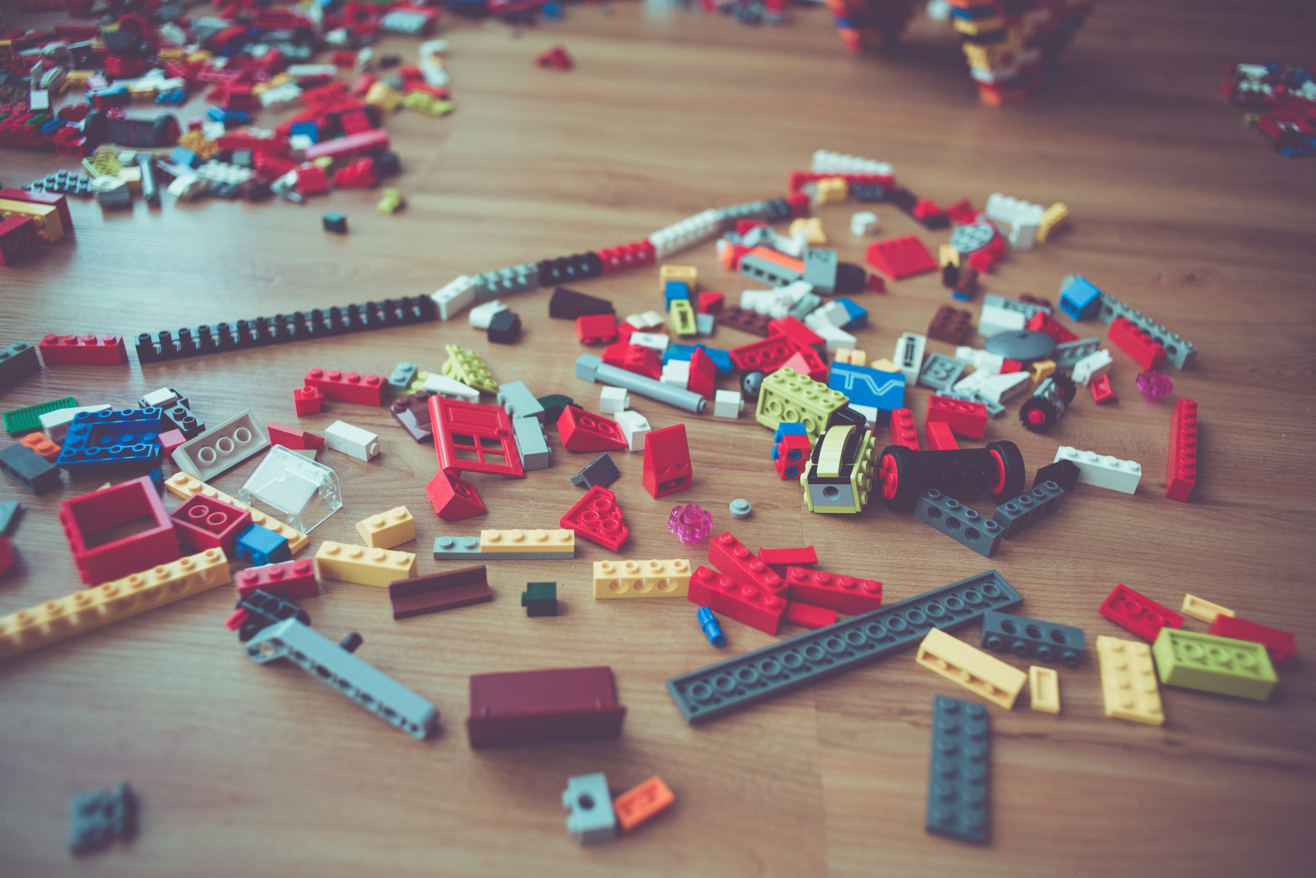 Colorful legos on a hardwood floor. 