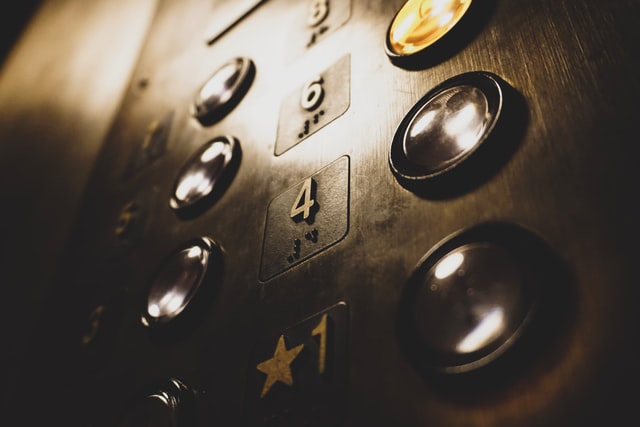 A close-up of call buttons on a gleaming, metallic elevator. 