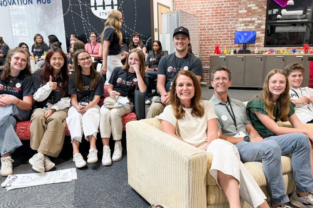 Candace Couch, center, and her family pose for a photo with the New Media Institute student team that worked on GKnow