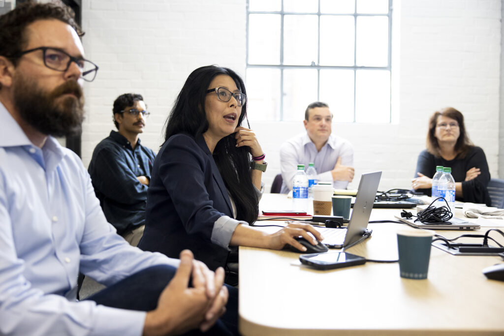 Exectutives gather around a conference table in the Innovation Hub