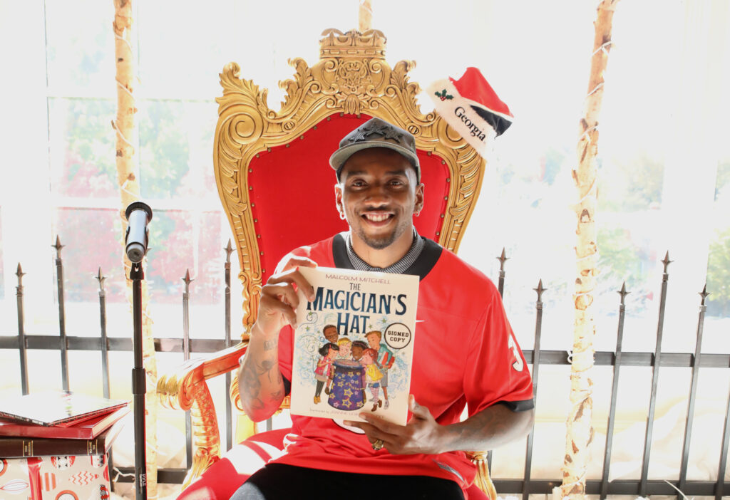 Former Super Bowl champion and Georgia Bulldog Malcolm Mitchell poses with childrens book 